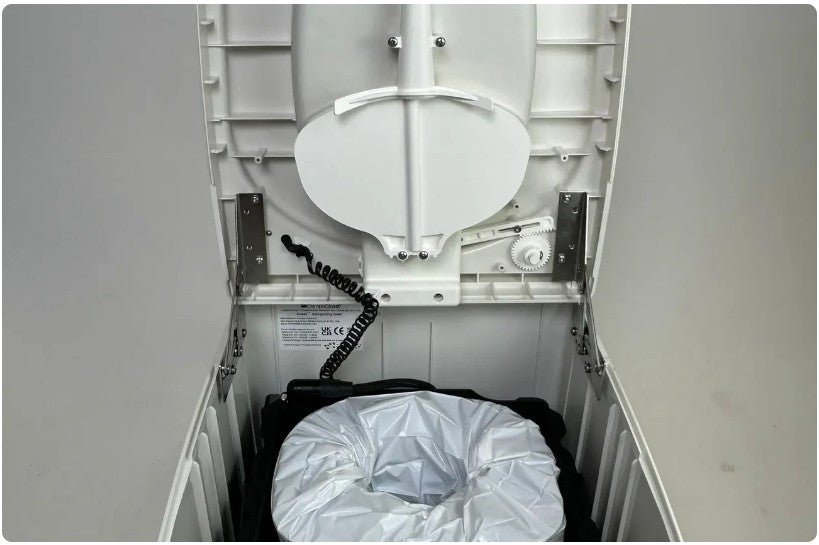 Compact toilet with a white cover inside a small enclosed space.